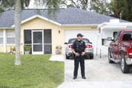 A cop stands in front of Brian Laundrie's parents' residence in 2021. (Image via Getty)